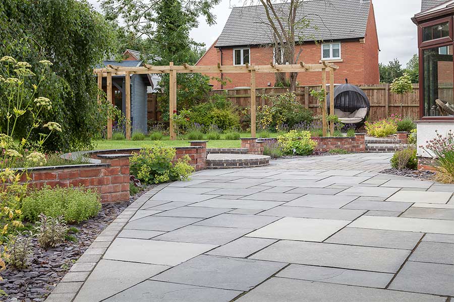 Large patio paved with grey AWBS Noire natural limestone paving slabs